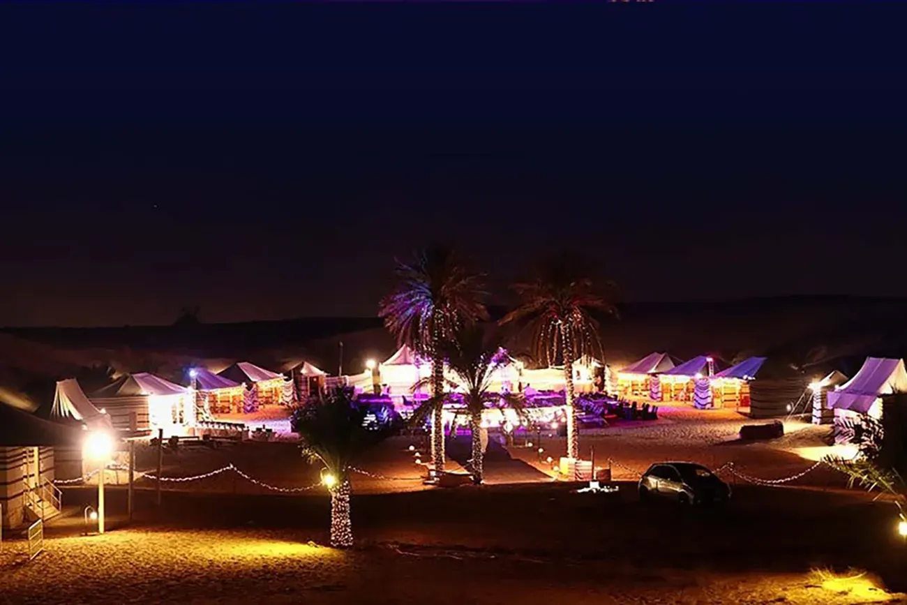 A desert camp illuminated at night